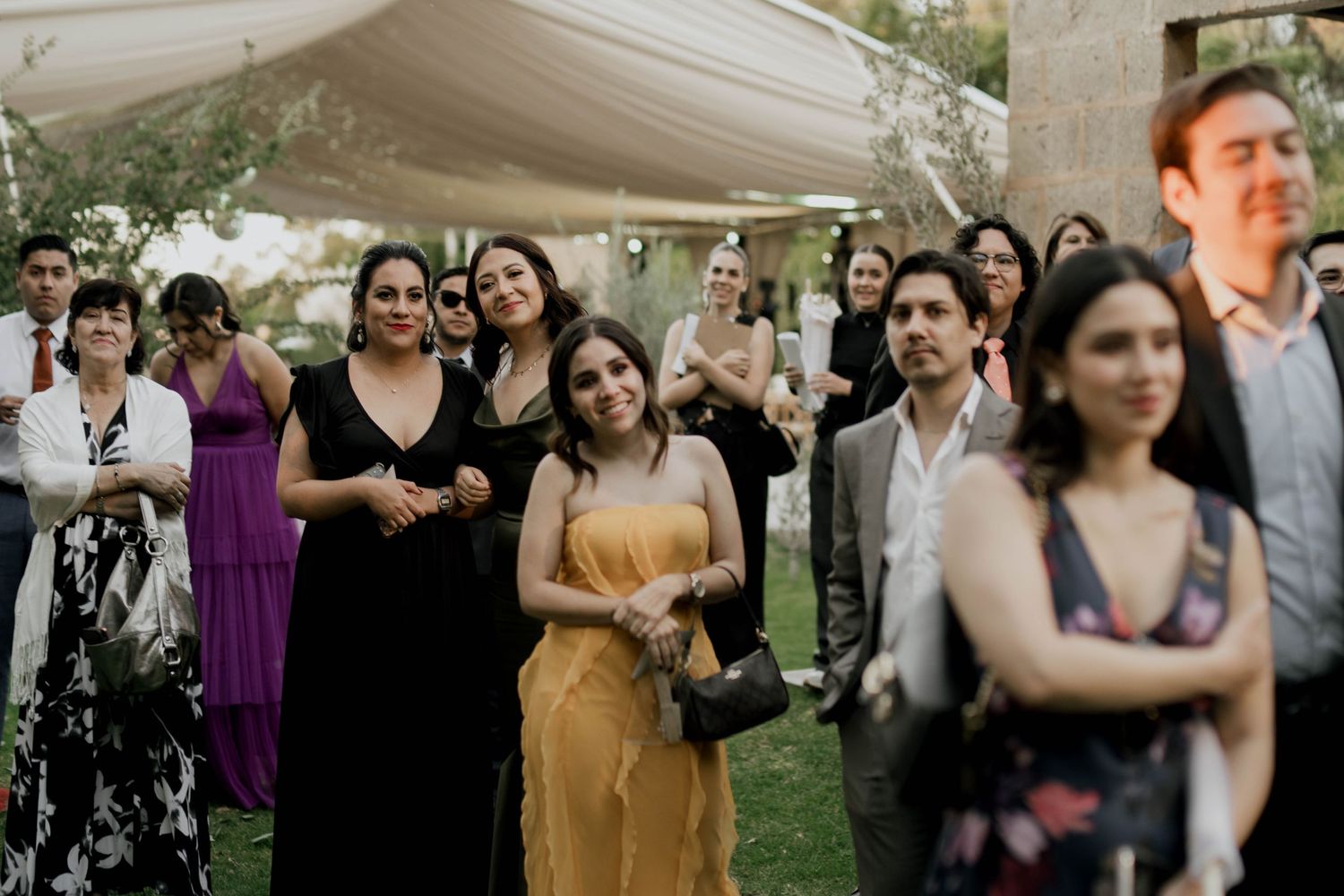 Wedding guests mingle and socialize during an outdoor garden reception.