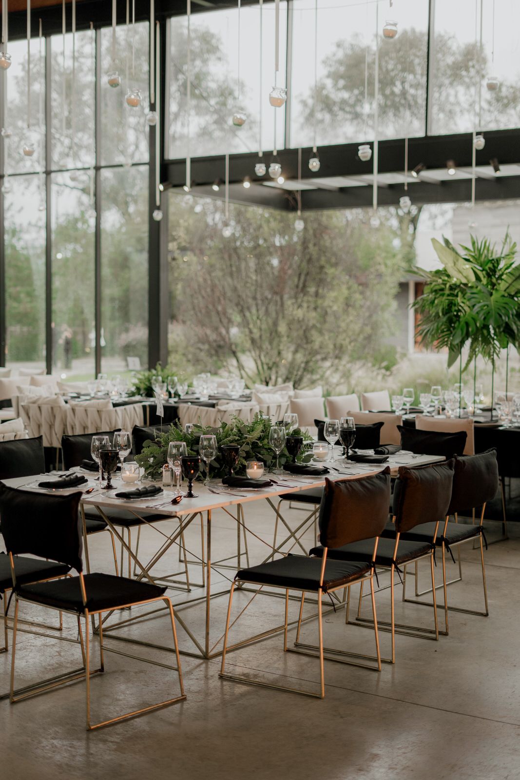 Contemporary dining setup with geometric chairs and tables arranged in a bright, window-lined venue.