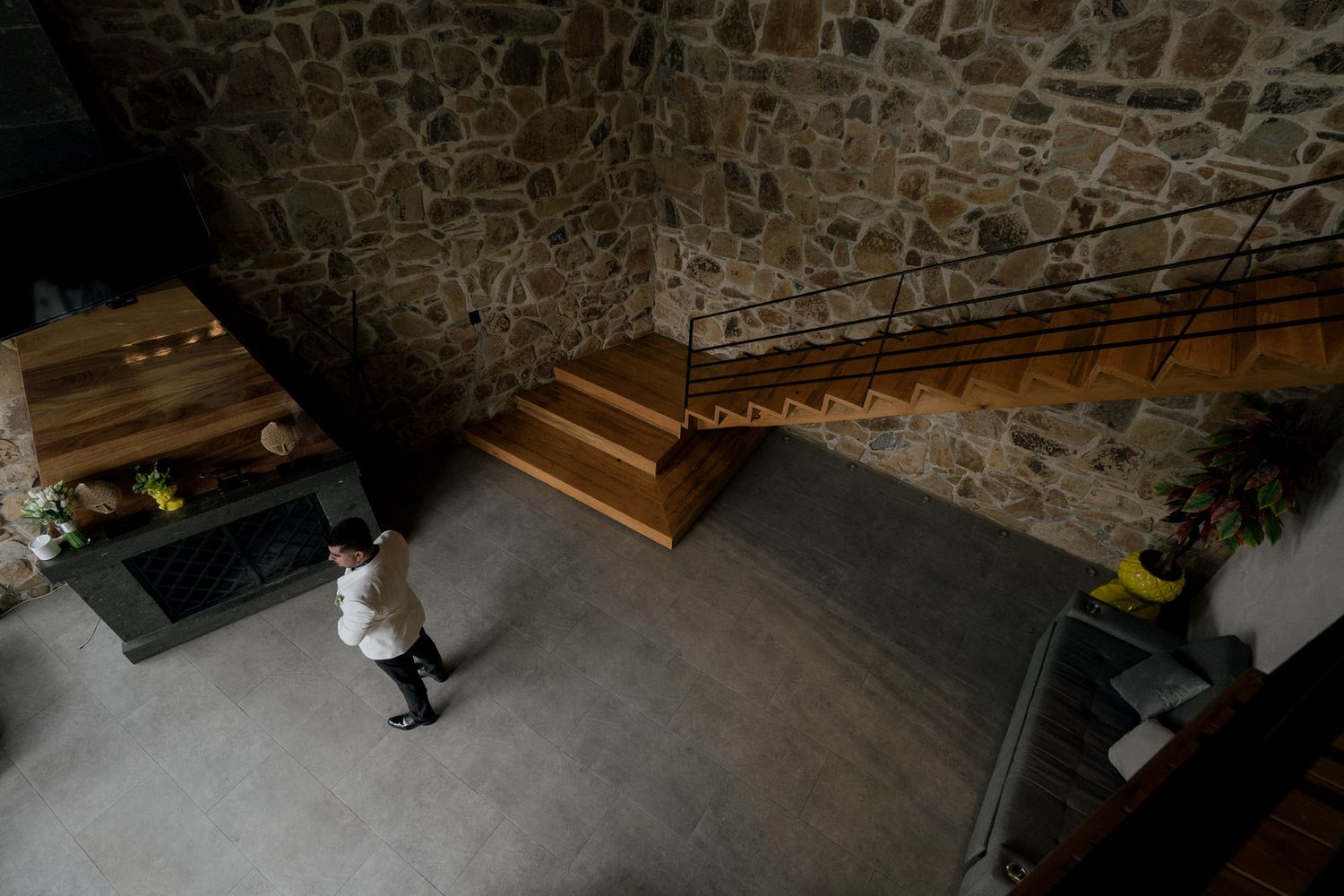 A rustic stone wall interior with wooden stairs and modern decor in an elegant venue space.