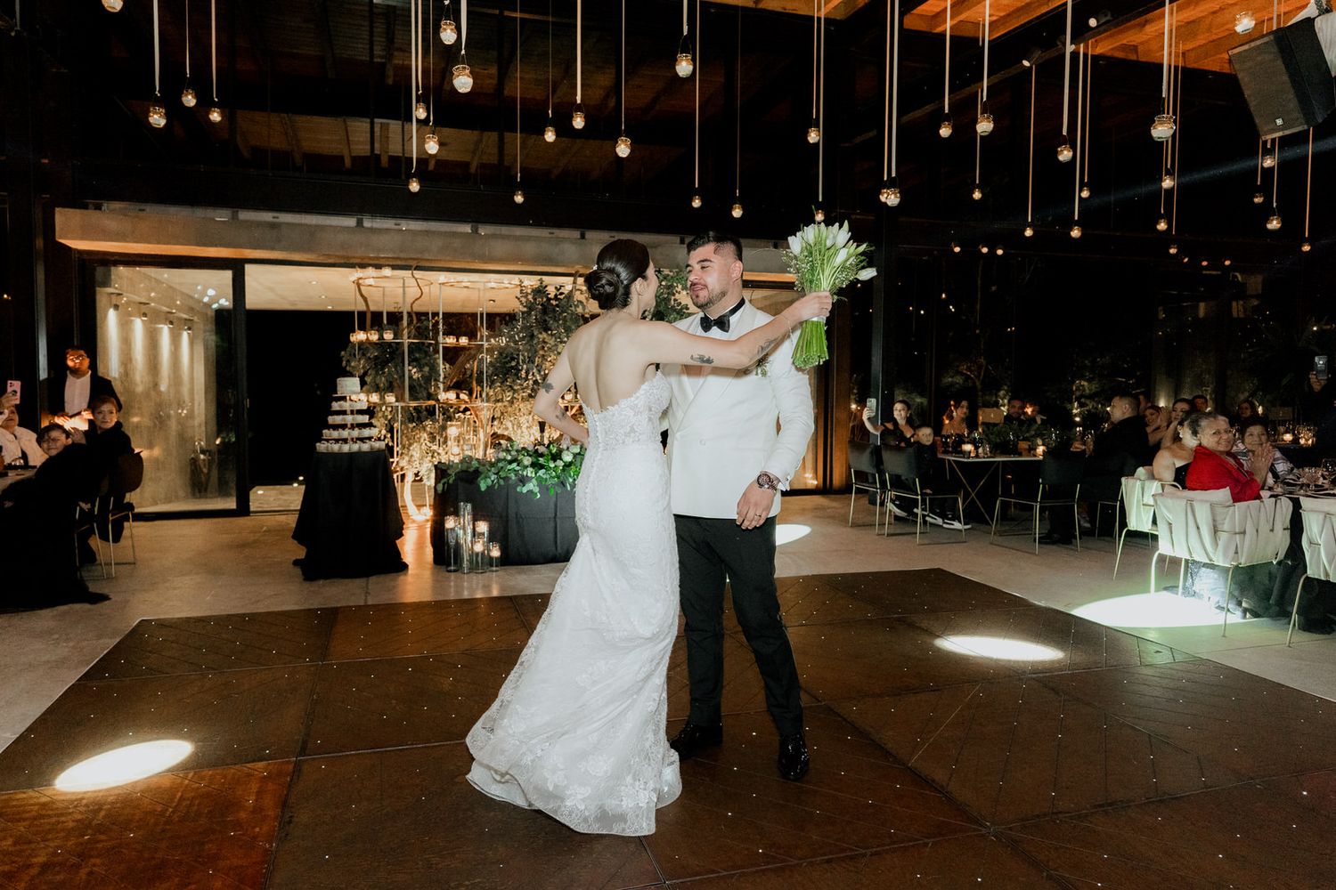 Wedding reception dance floor illuminated by suspended string lights creating a magical atmosphere.