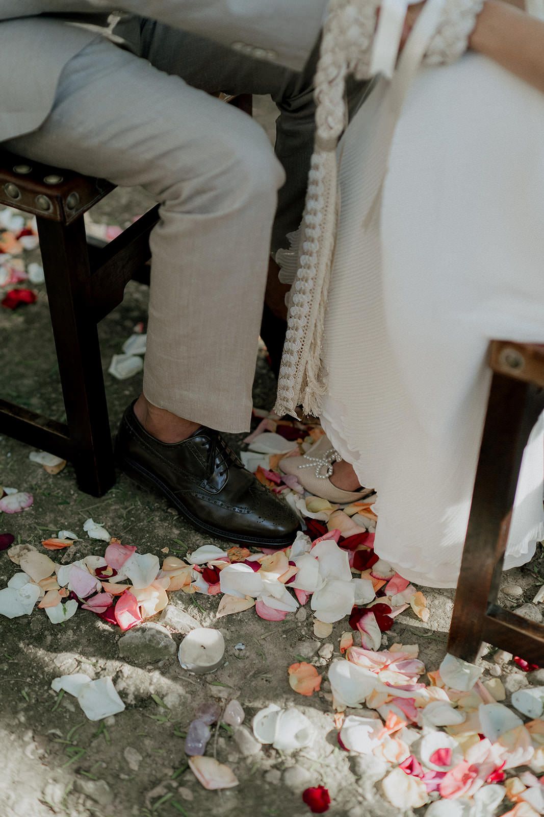 Rose petals scattered on a stone pathway creating a romantic wedding aisle decoration.