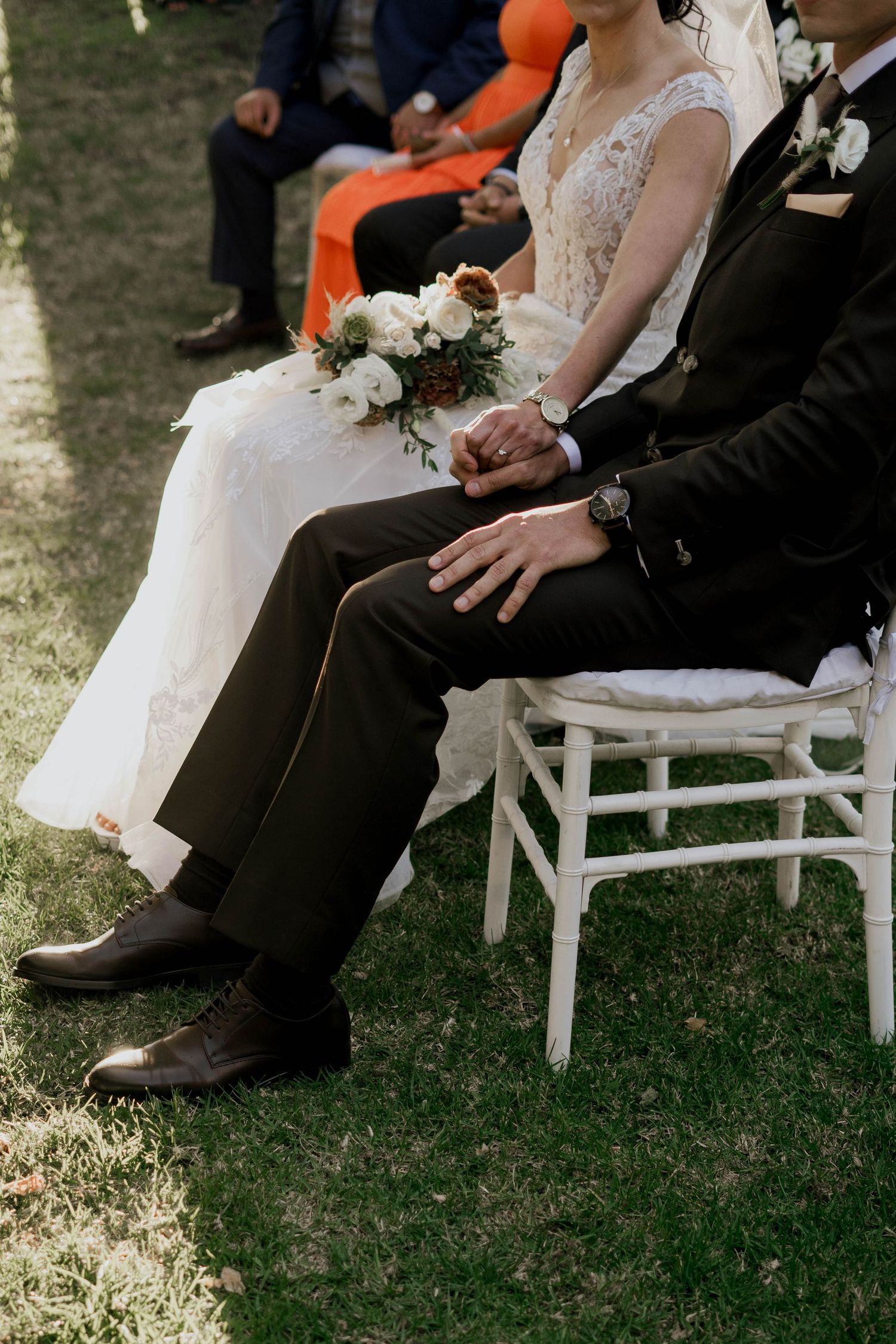 Close-up details of wedding attire and seating arrangements at an outdoor ceremony.