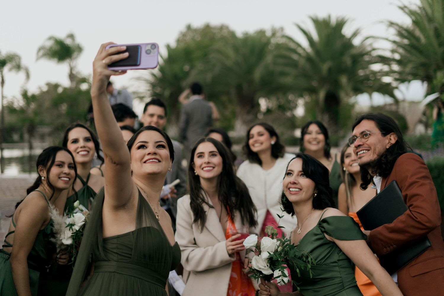Wedding guests taking photos and celebrating at an outdoor reception.