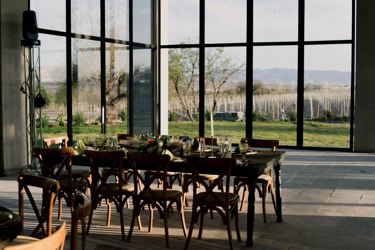 Modern wedding reception space with floor-to-ceiling windows overlooking natural landscape.