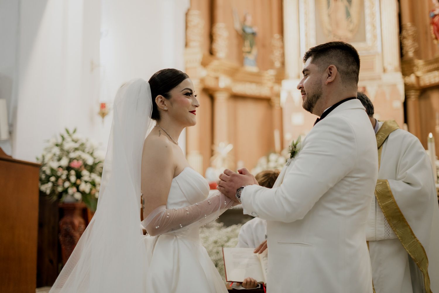 Bride and groom exchange vows during their ceremony in a beautifully decorated church.