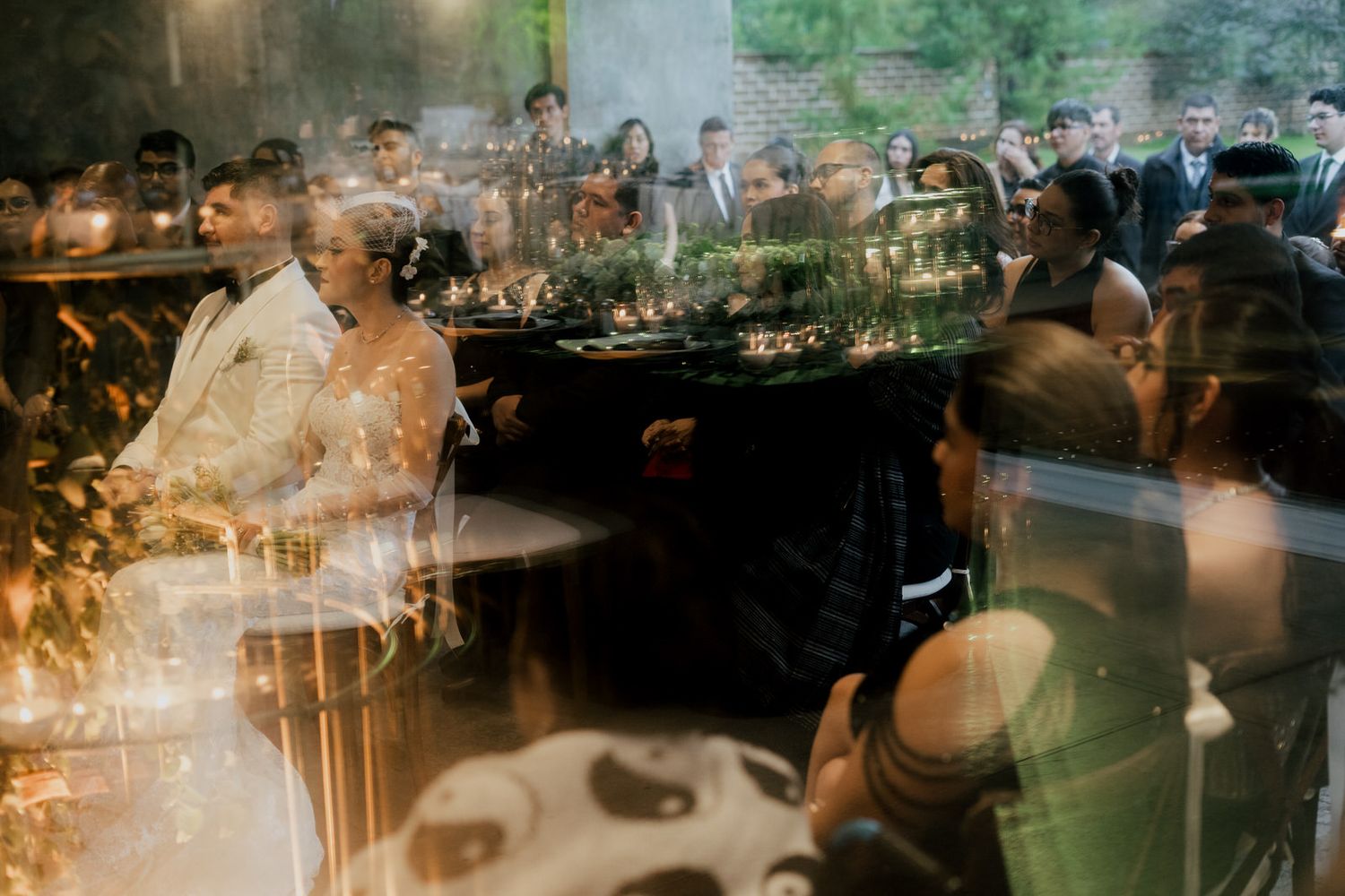 An artistic double exposure shot of wedding guests gathered at a reception venue.