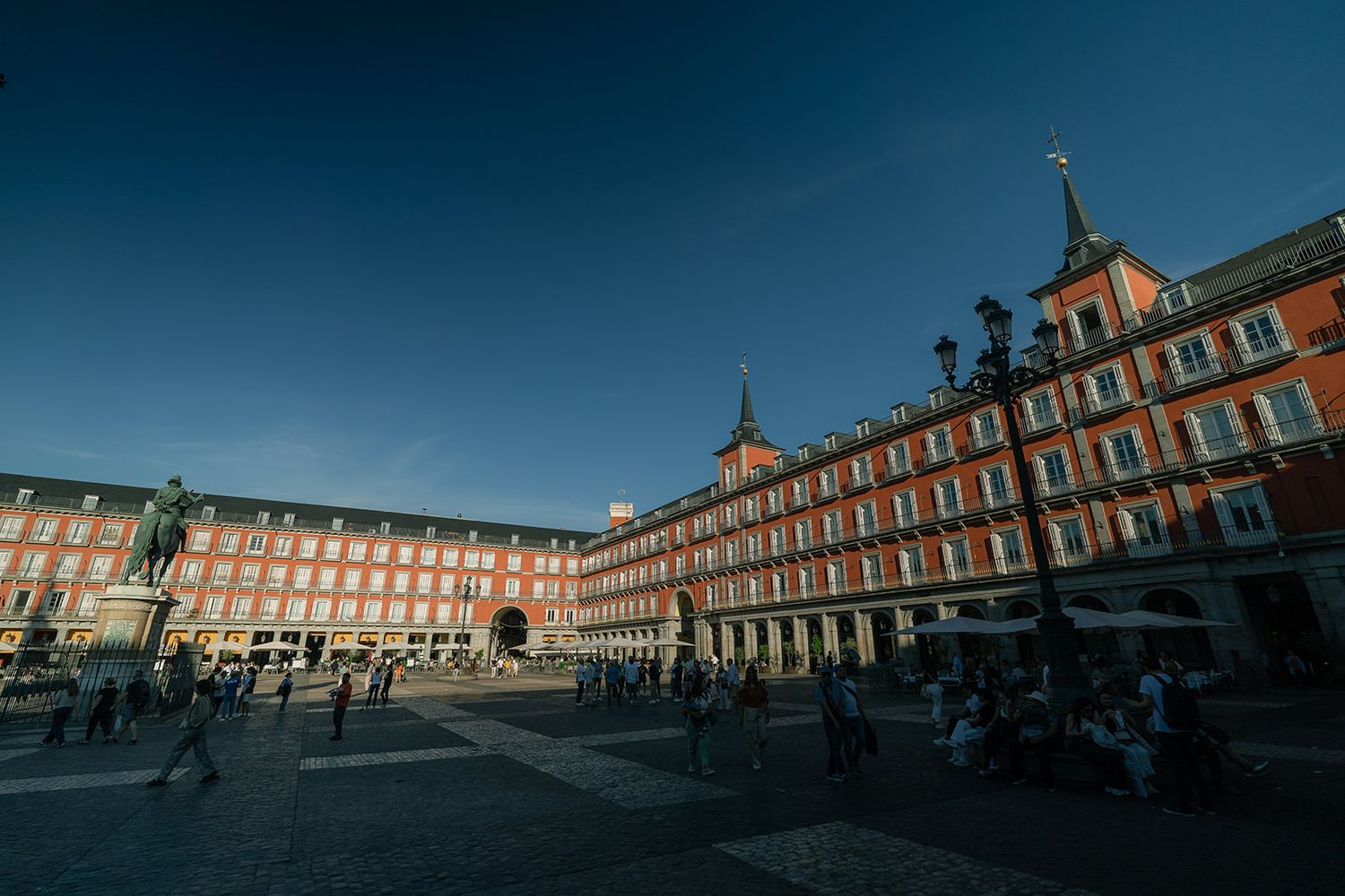 Panoramic sequence of Plaza Mayor in Madrid at sunset showing historic red brick architecture and arched colonnade.