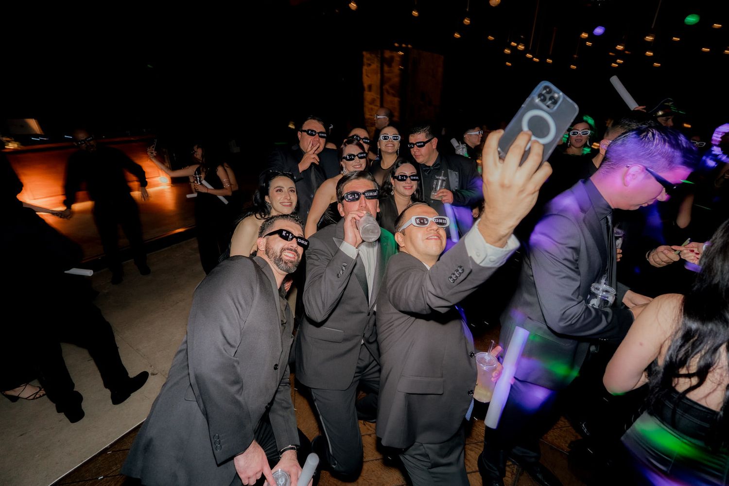 Energetic party scene with guests dancing under colorful lighting effects.