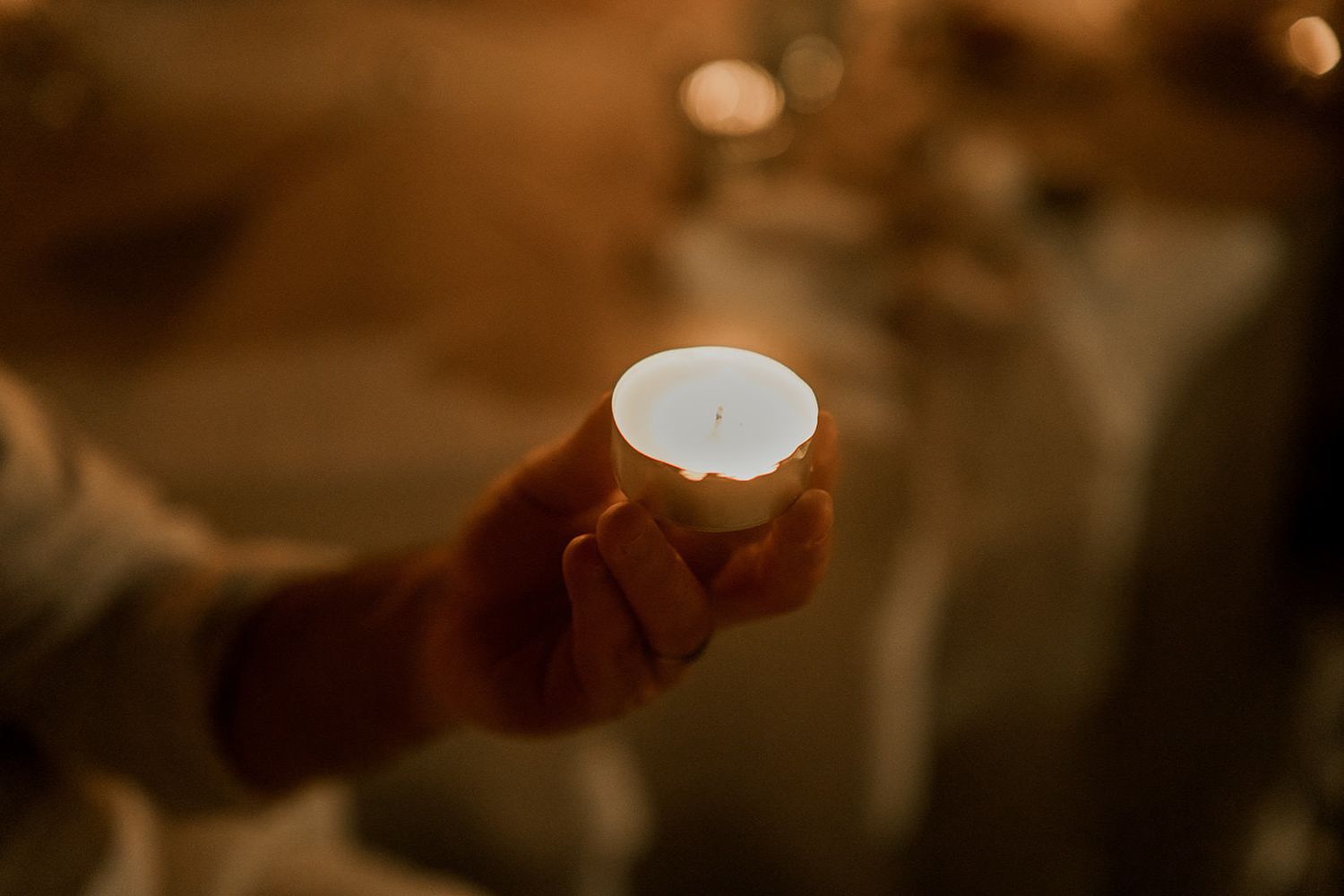 Warm bokeh lights create a romantic ambiance at an evening wedding celebration.