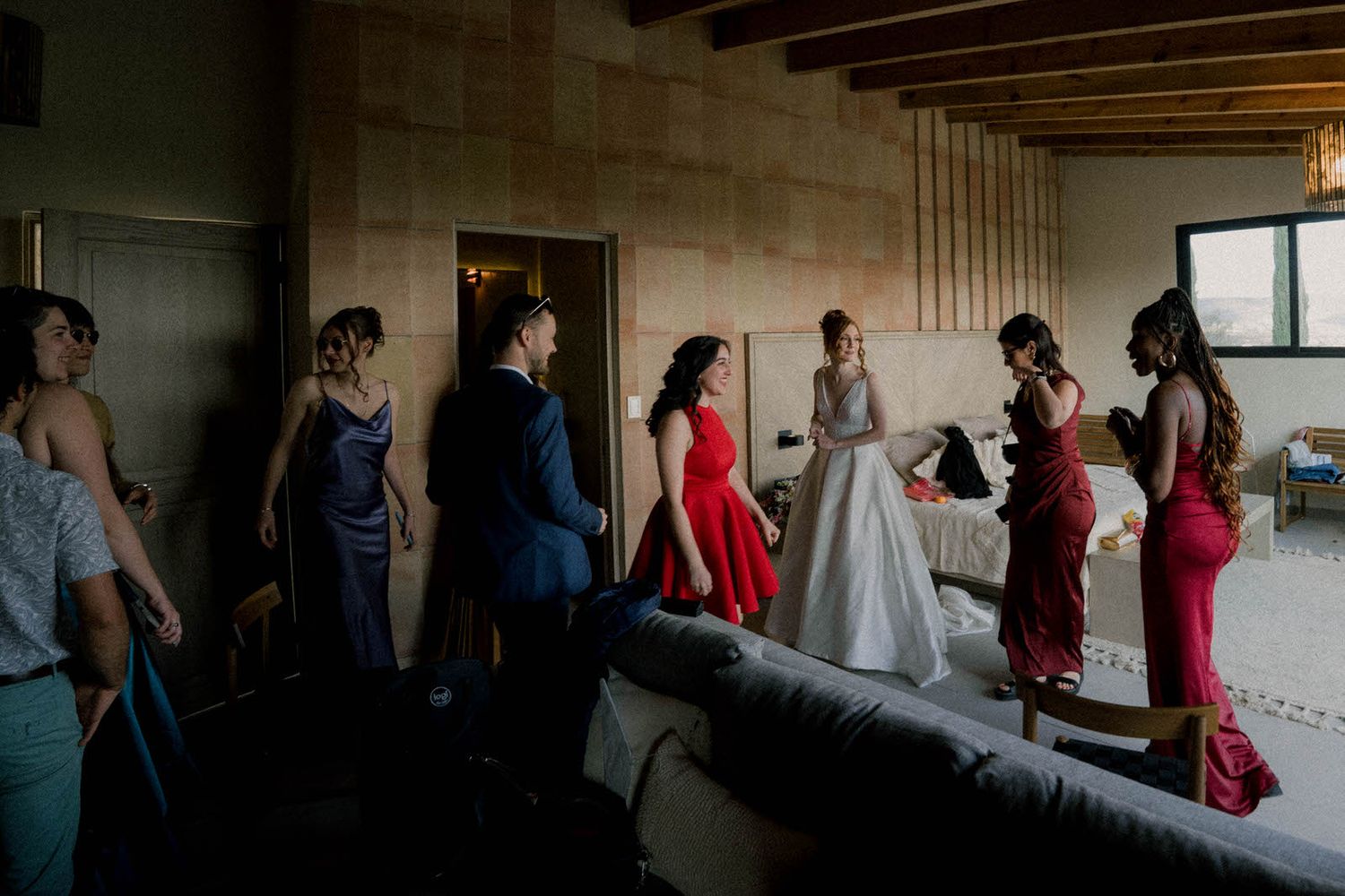 Wedding party members gather in a dimly lit room preparing for the ceremony.