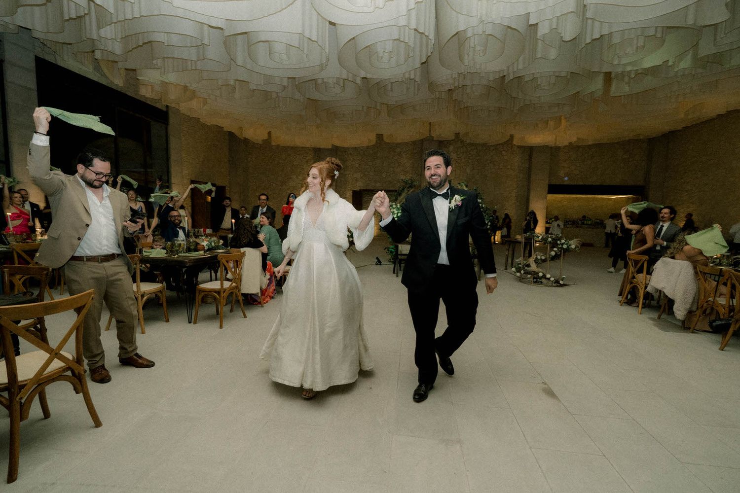 Panoramic shot of wedding reception venue showing stone architecture and guest seating arrangement.