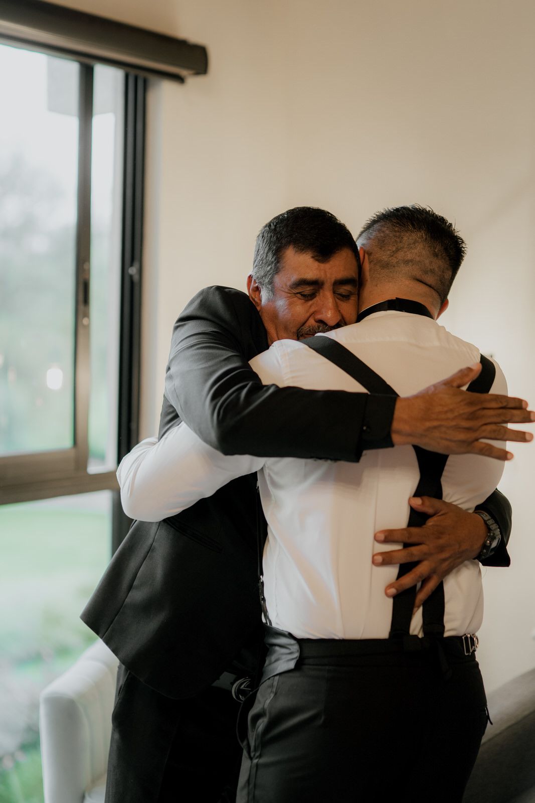 Groomsmen share an emotional group hug before the wedding ceremony.
