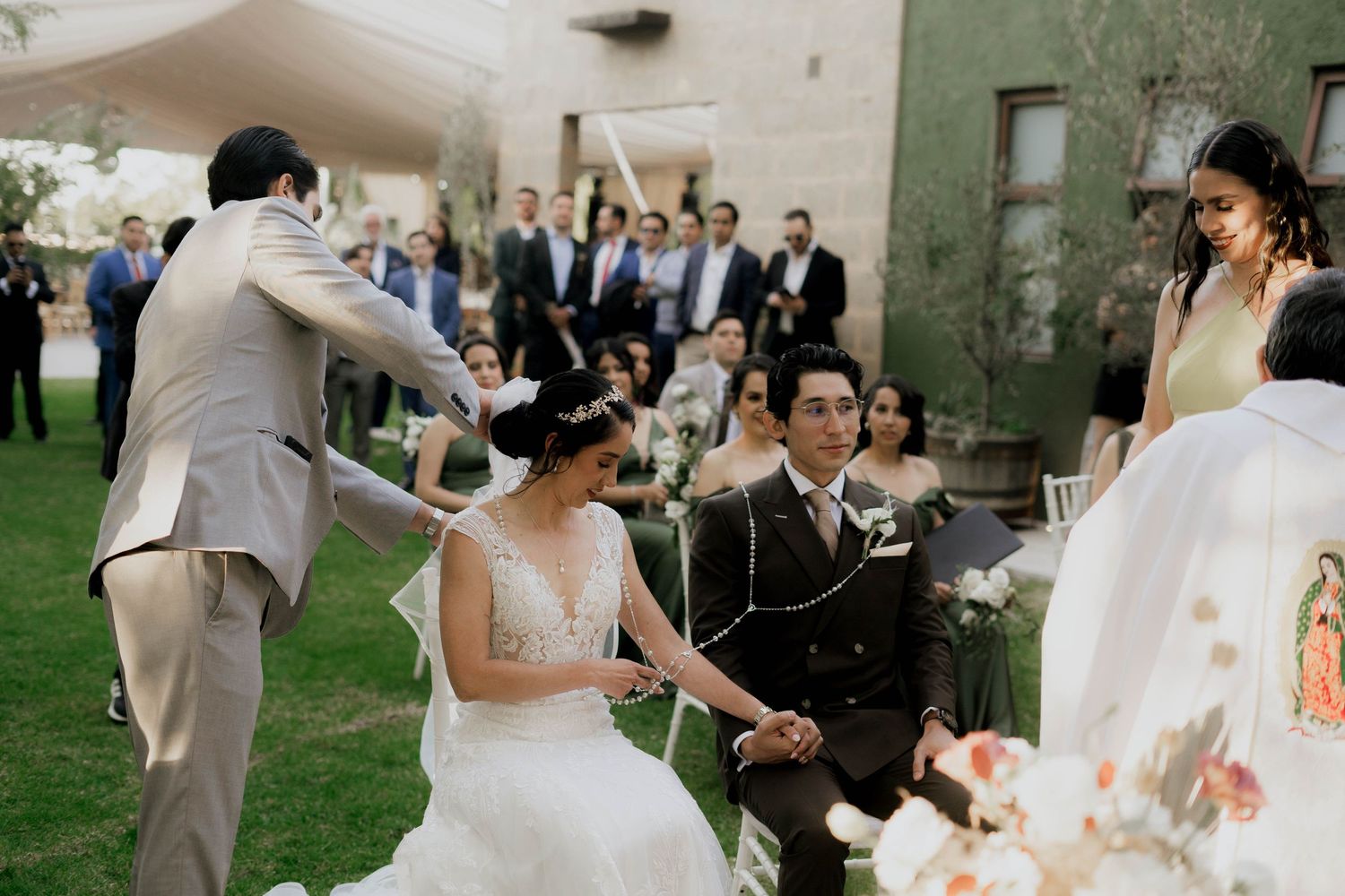 Wedding celebration in progress on outdoor lawn with decorative lighting.