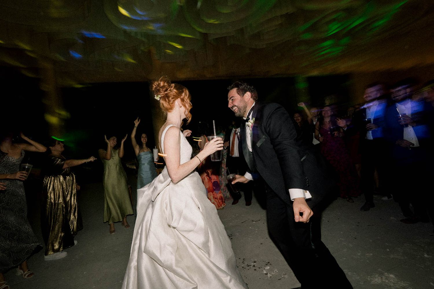 Couples dancing together at an evening wedding reception.