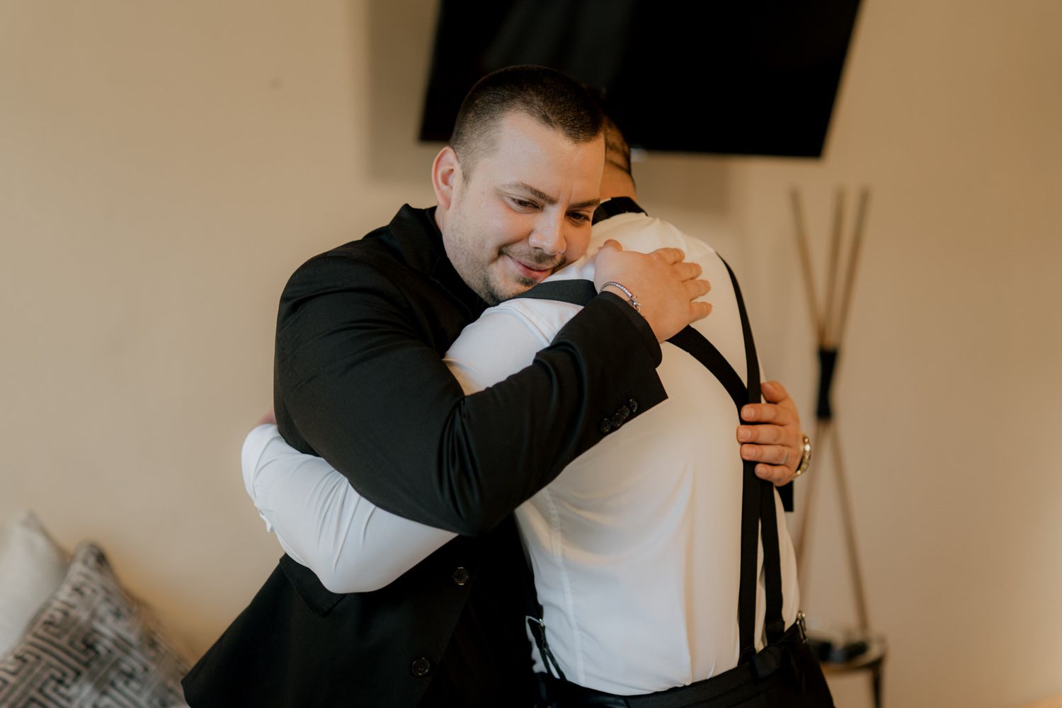 Wedding party members share an emotional embrace while getting ready for the ceremony.