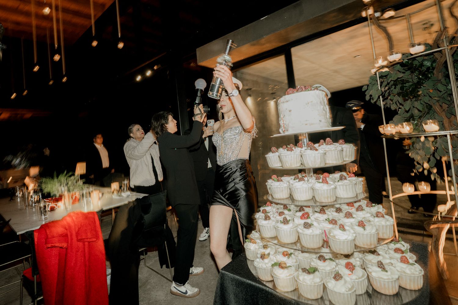 Wedding reception with tiered cupcake display and decorative lighting creating an elegant atmosphere.