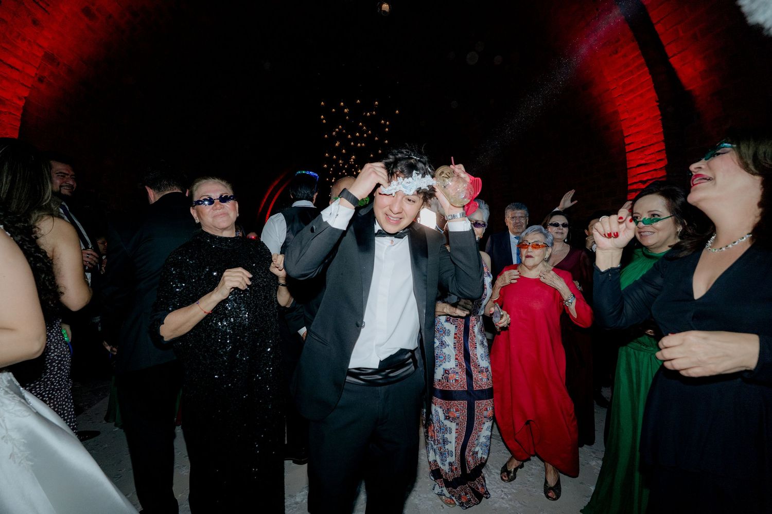 Lively dance floor scene at a wedding reception with guests in formal attire.