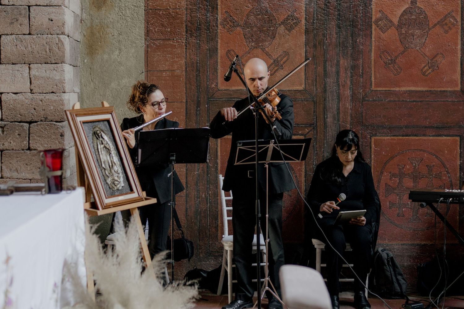 String musicians performing at a wedding in a historic brick venue.