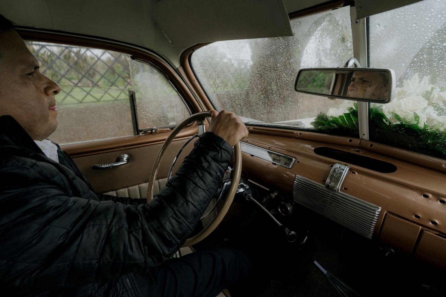 Classic car interior dashboard and steering wheel details shown in warm lighting.