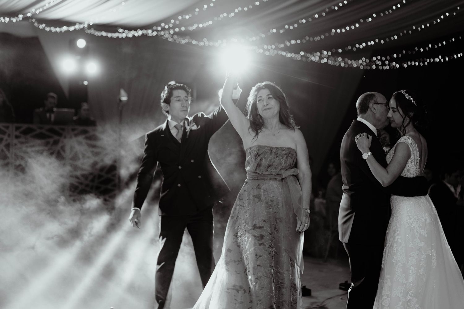 Elegant wedding dance floor scene with dramatic lighting and smoke effects.