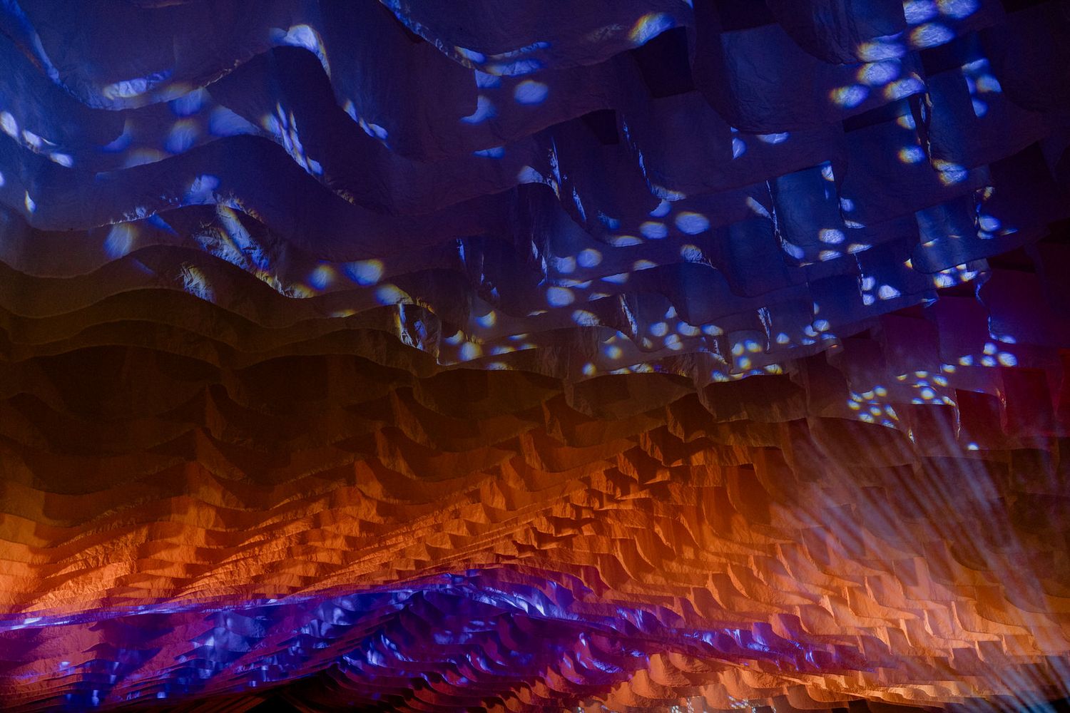 Abstract light painting photography featuring vibrant blue and orange wavy patterns with bokeh effects.