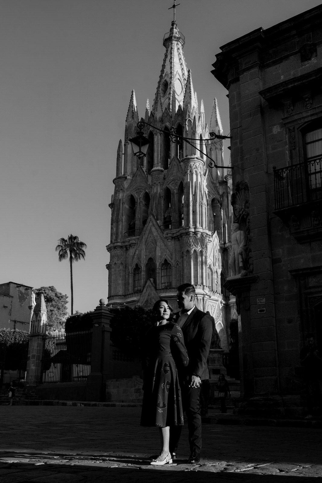 Gothic cathedral spires rise dramatically against black and white sky in San Miguel de Allende.