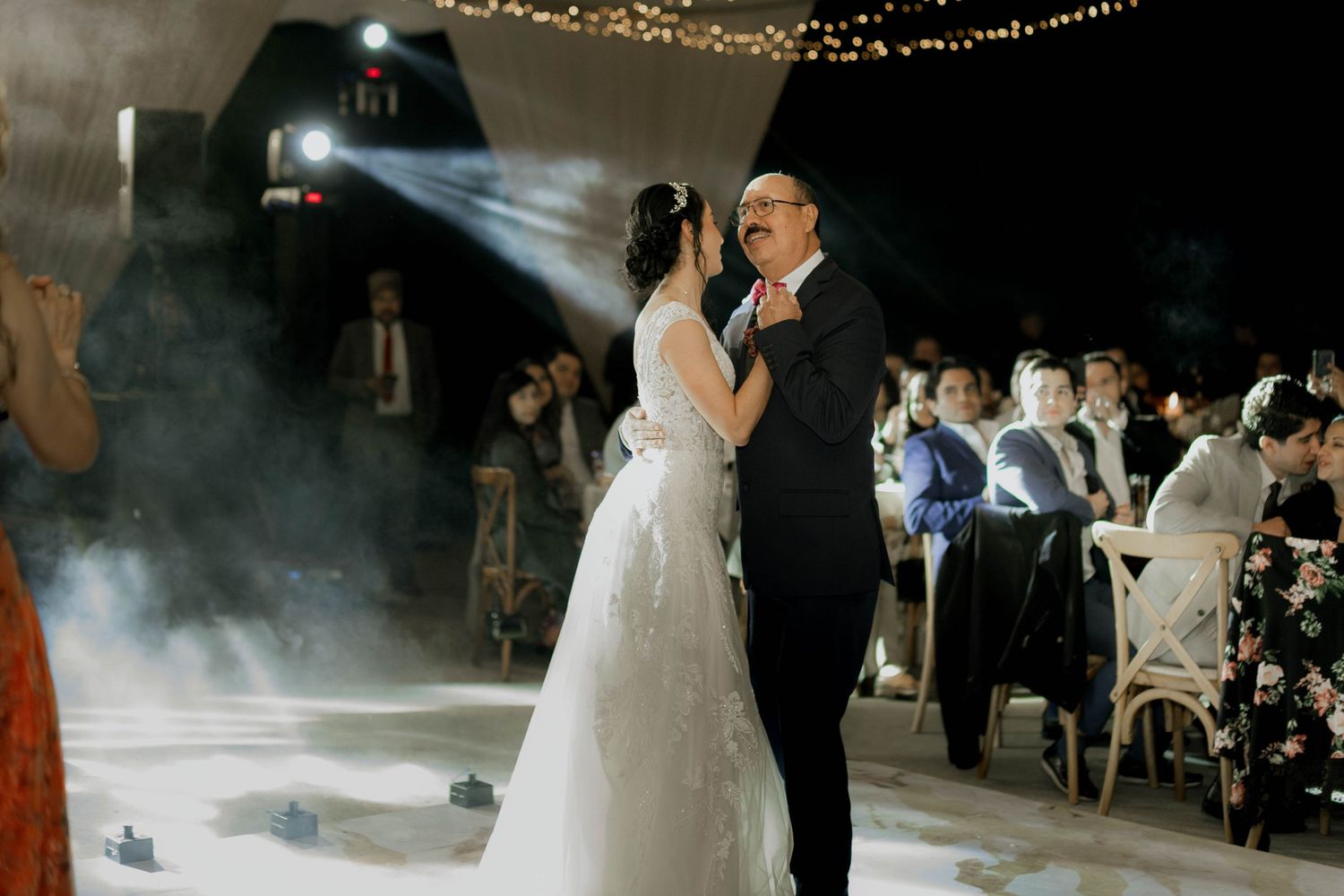 Atmospheric wedding dance with fog effects and string lights creating a romantic ambiance.