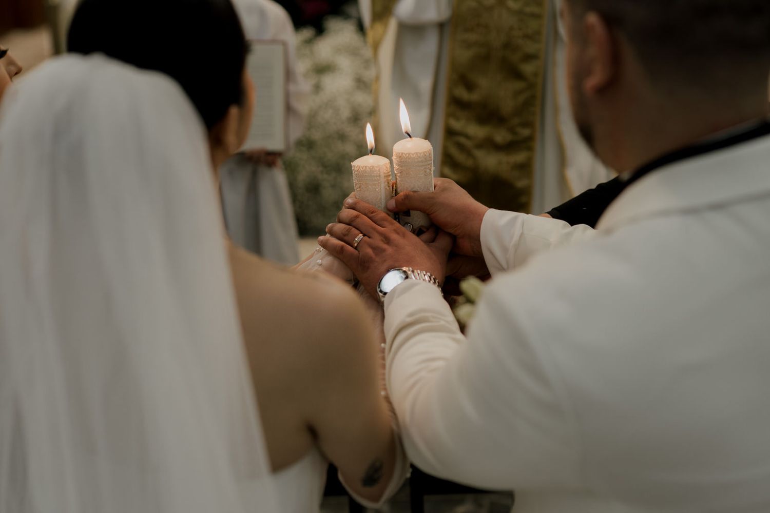 Close-up shot of hands during a wedding ring exchange ceremony.