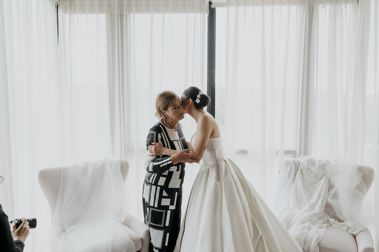 A touching pre-wedding scene with white curtains and natural light.