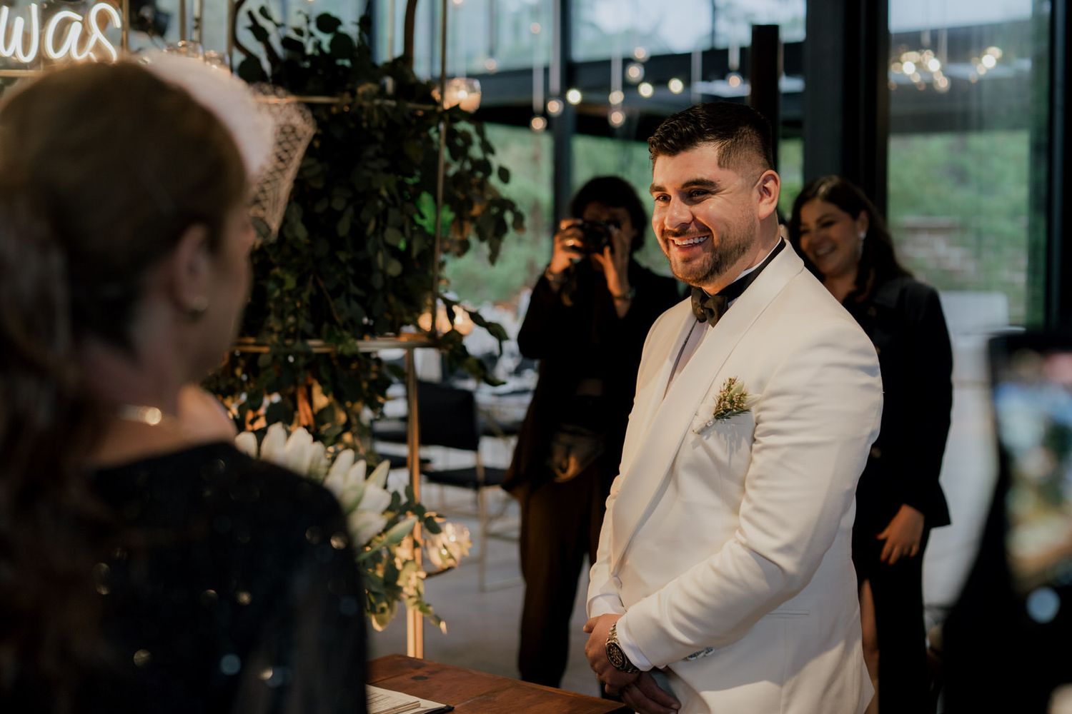 Wedding reception celebration in modern indoor venue with mood lighting.