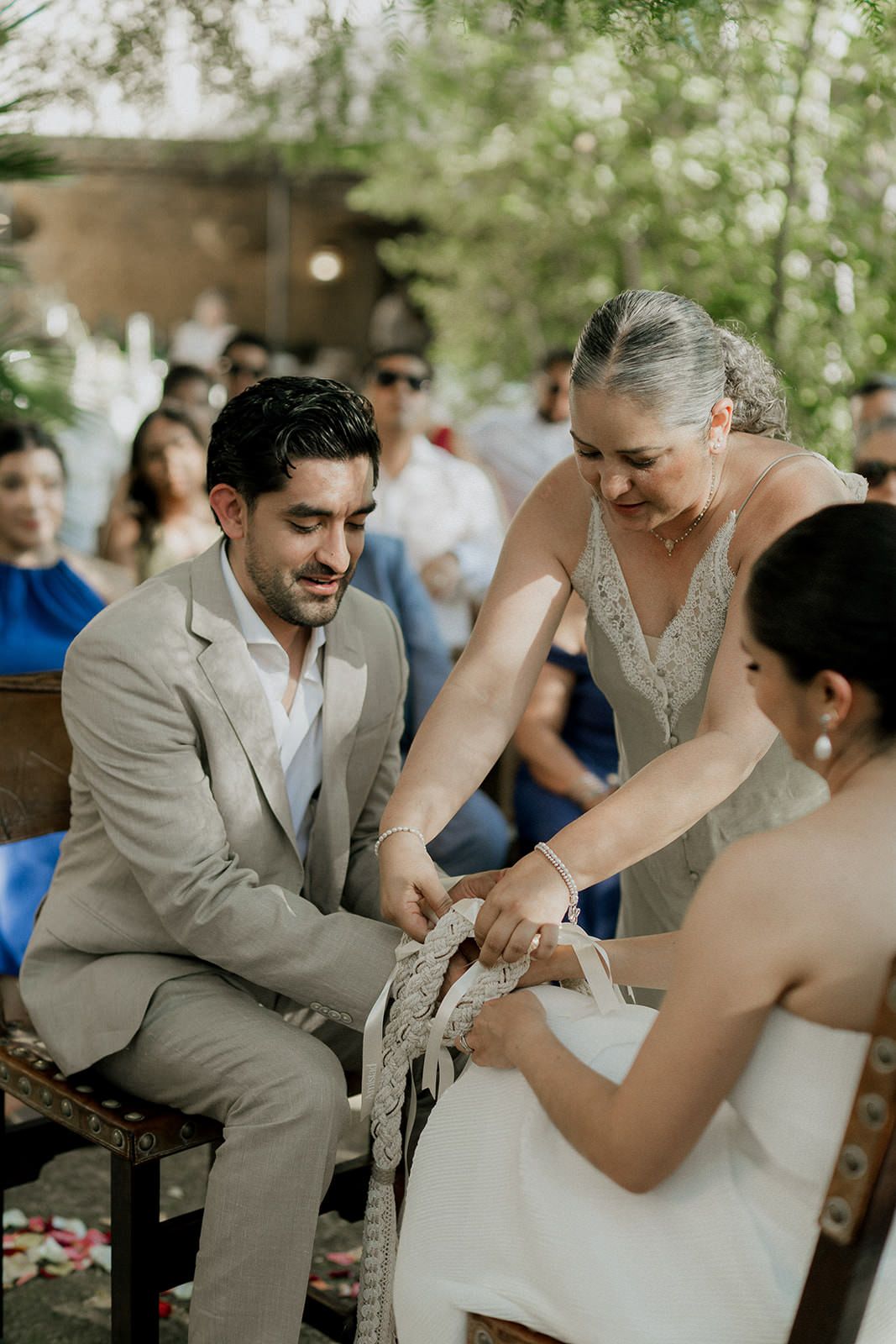 Wedding couple shares a playful moment during their outdoor ceremony under trees.