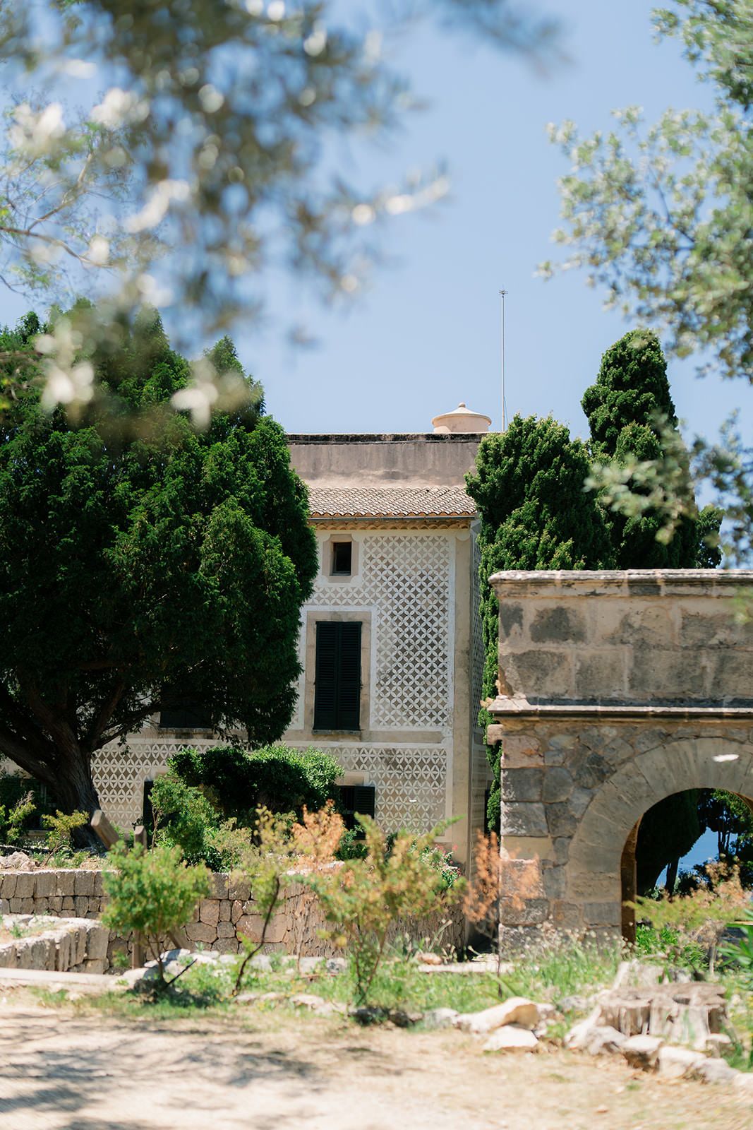 Mediterranean style stone building with latticed windows and rustic architectural details.