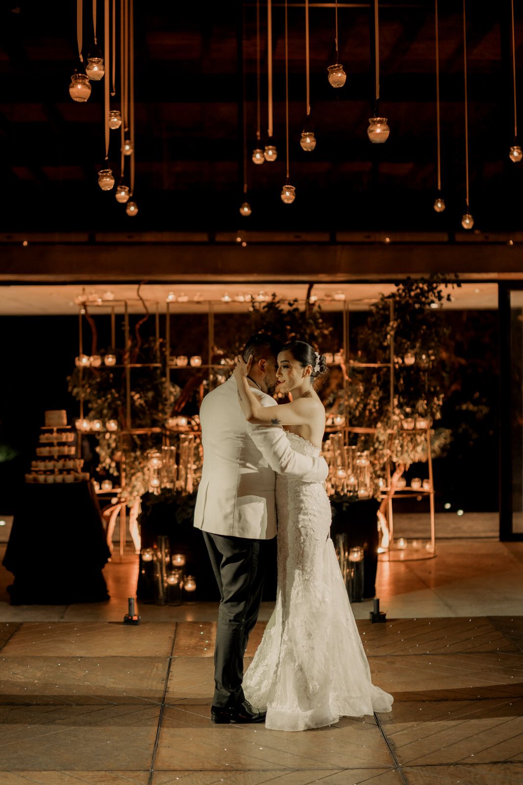 Couples sharing romantic dances on wedding reception floor under ambient lighting.