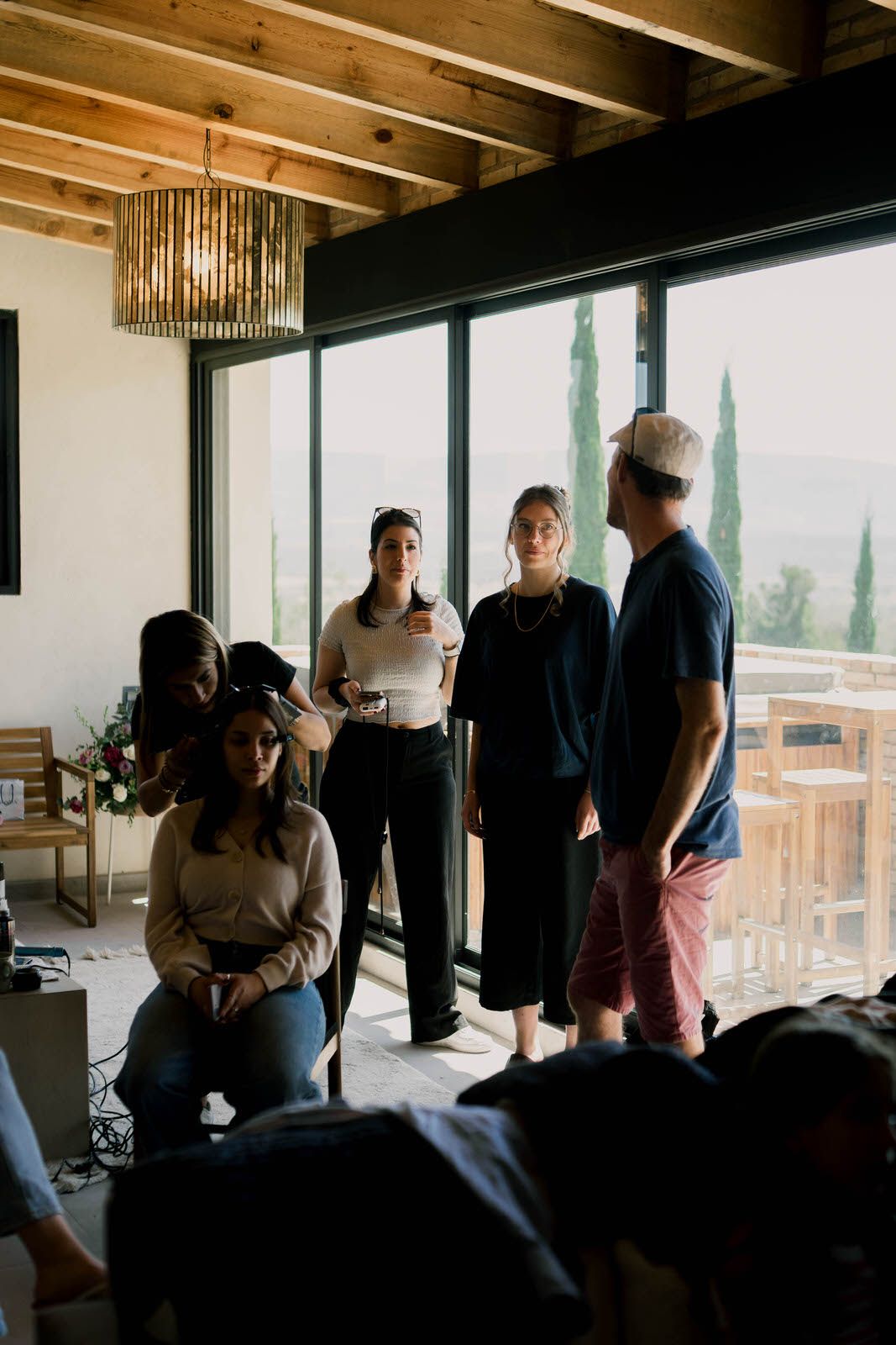 Modern venue space with exposed wooden beams and large windows overlooking an outdoor area.