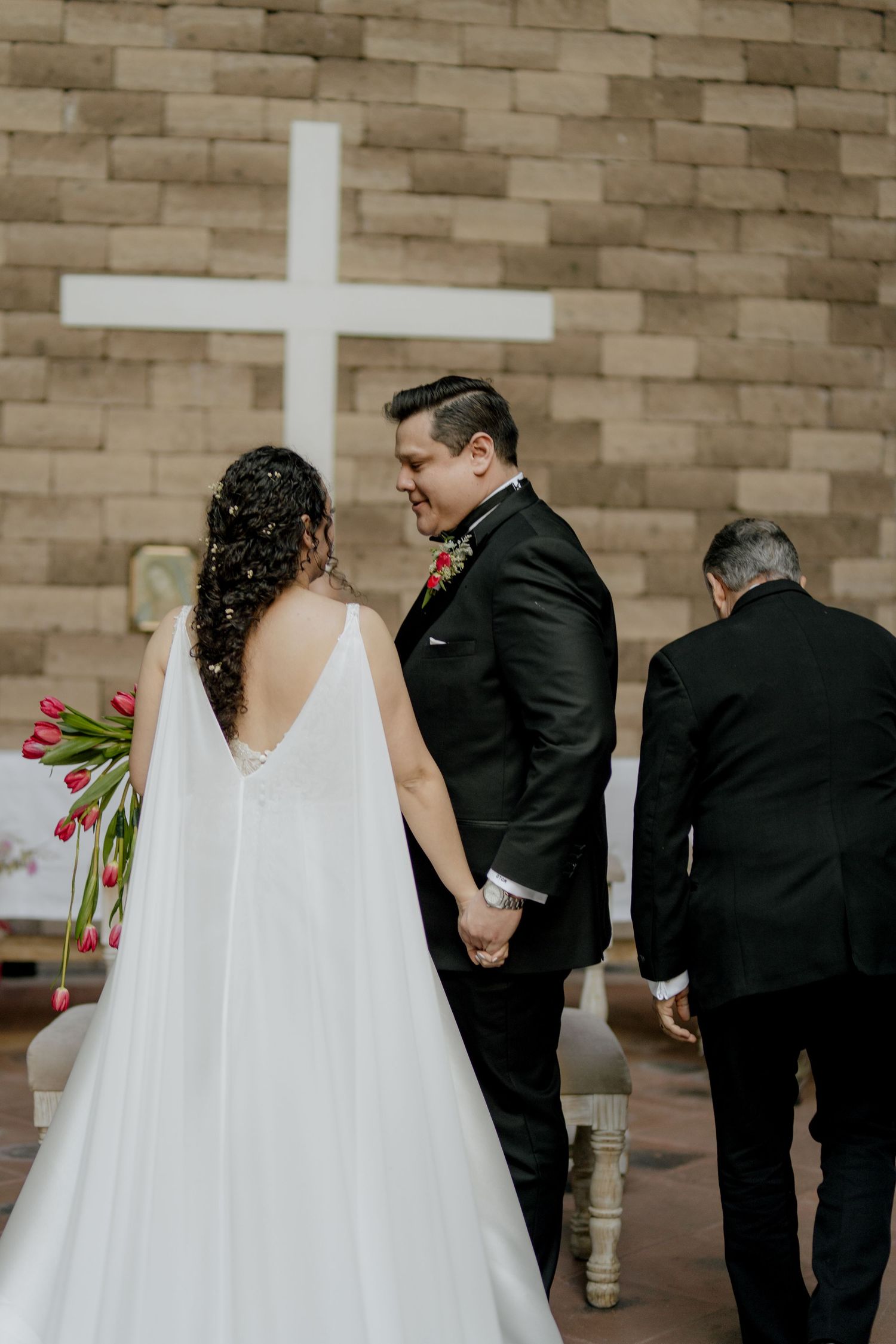 A wedding ceremony sequence showing a couple in formal attire against a stone wall backdrop.