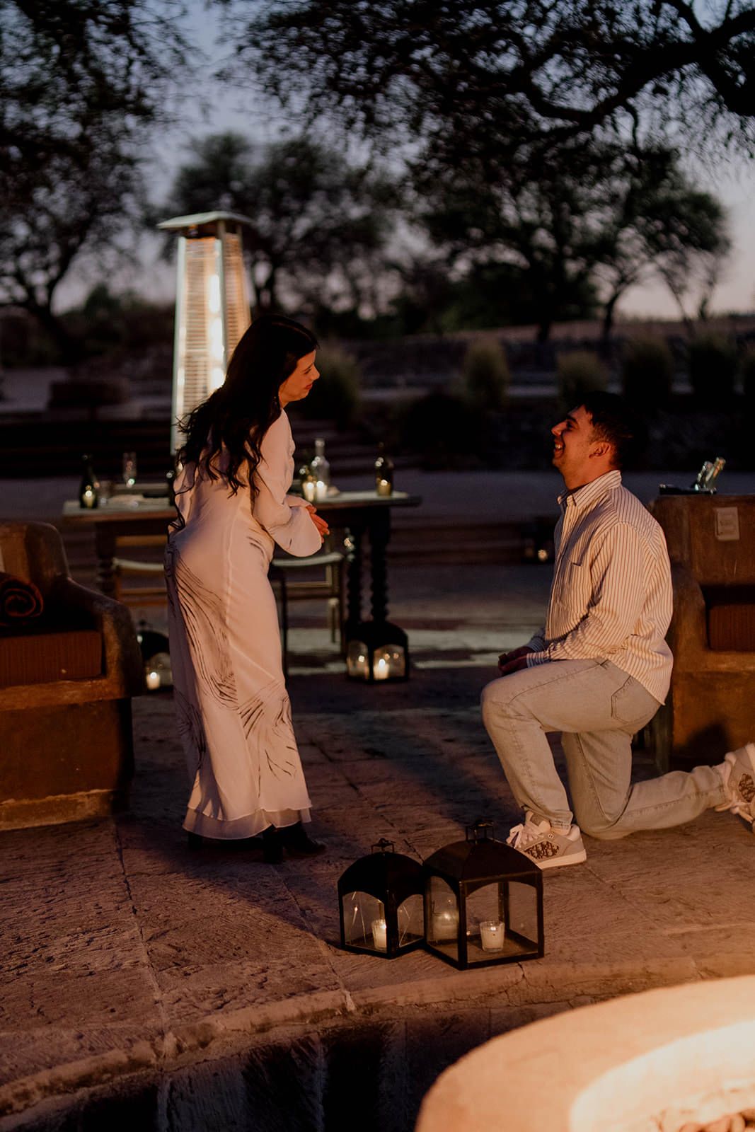 A proposal scene captured at dusk with decorative lanterns creating ambiance.