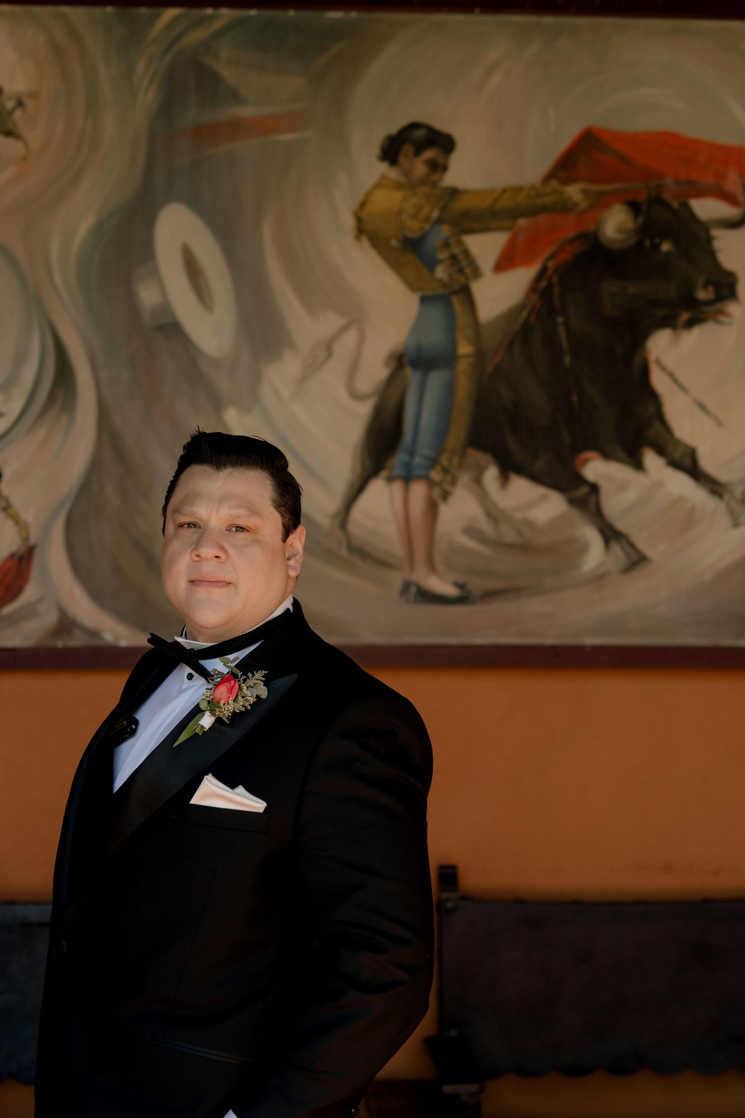 Wedding ceremony setting with decorative murals and formal attire.