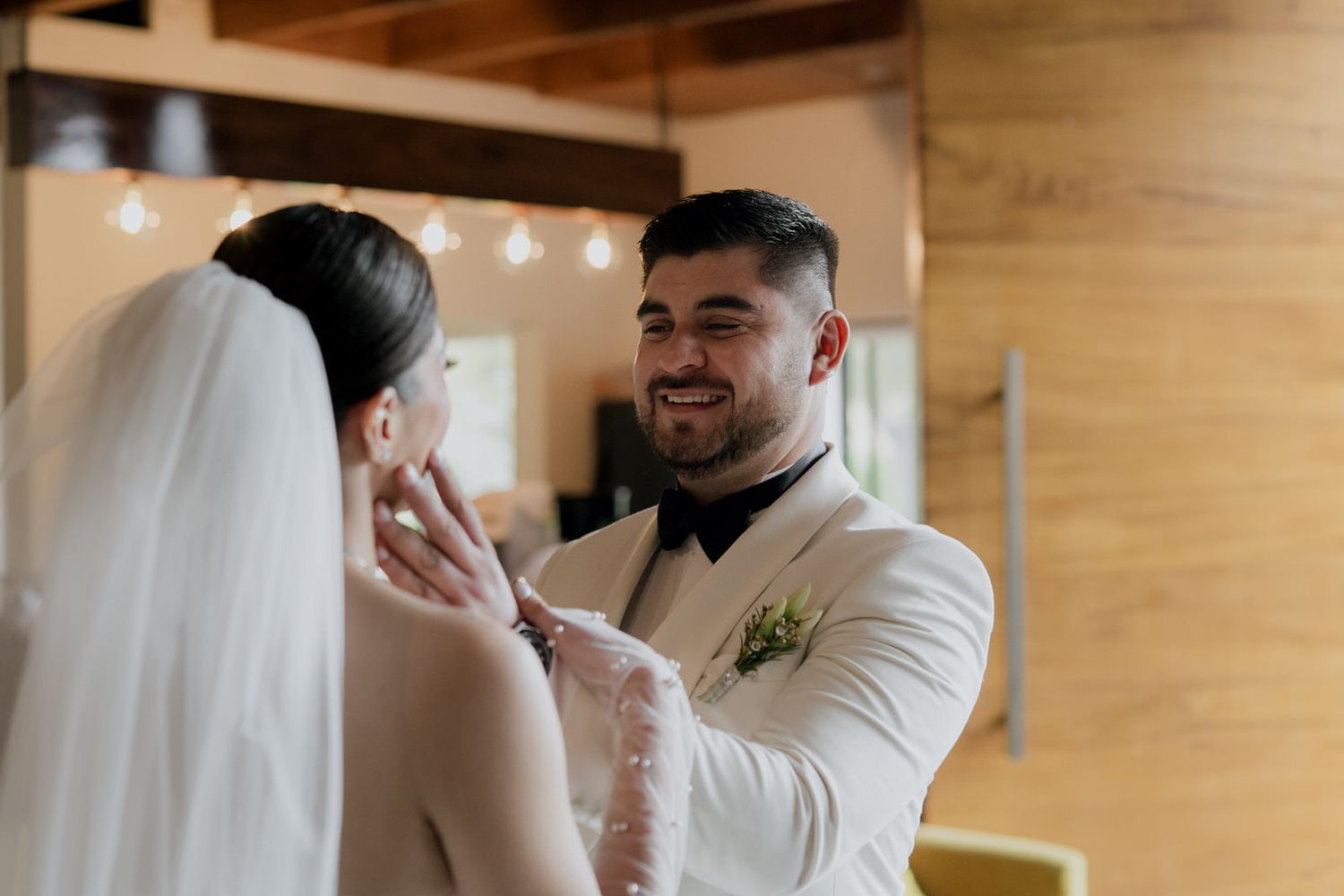 Emotional first look moment between couple in elegant white wedding attire.