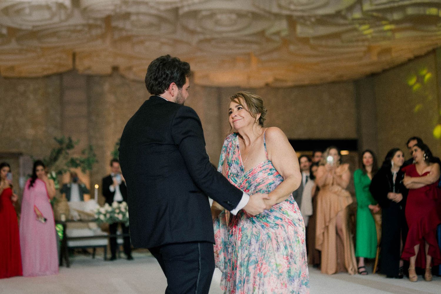 Couple sharing a romantic dance moment at a wedding reception with guests watching.