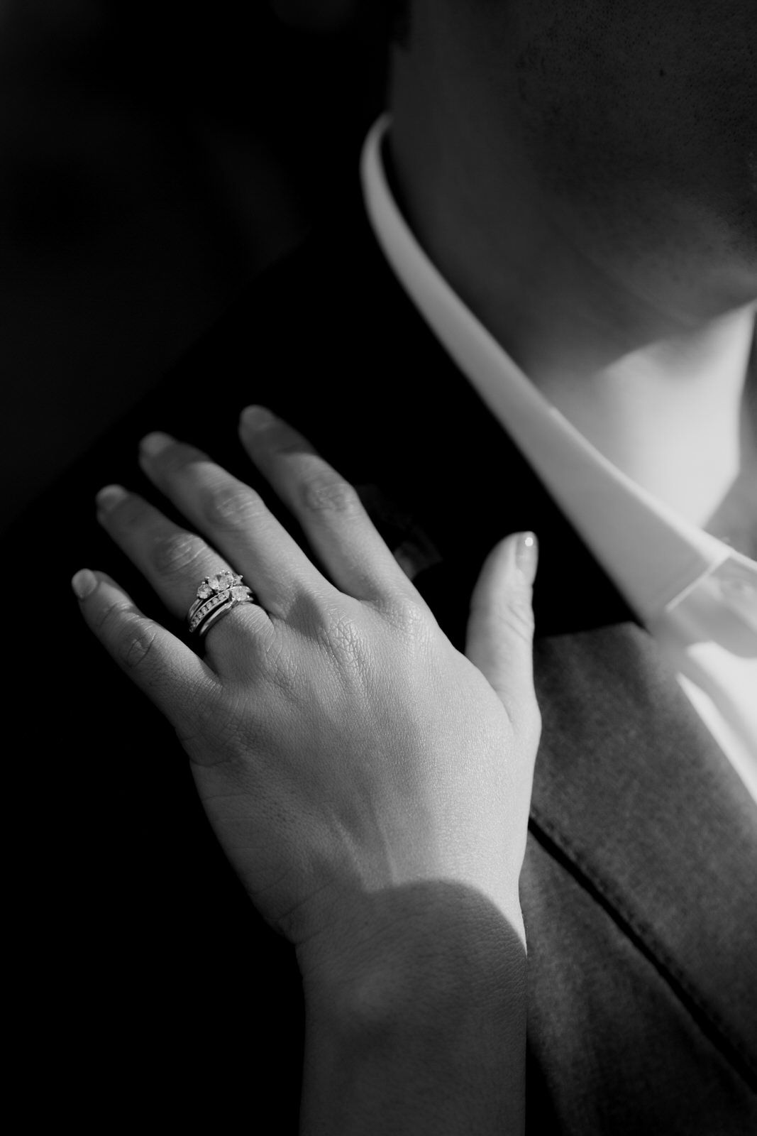 Close-up black and white shots of hands with an engagement ring.