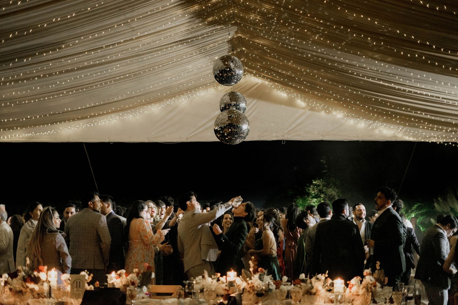 Wedding reception venue with warm lighting and draped ceiling creating an intimate atmosphere.
