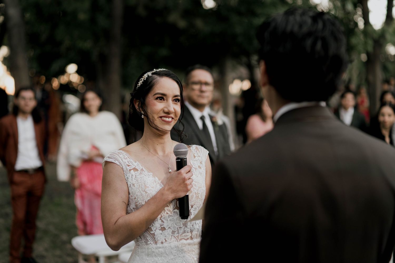 Outdoor wedding ceremony with guests watching the couple exchange vows.