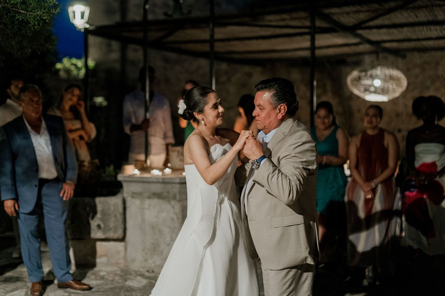 Couples dancing together at an evening wedding celebration in a dimly lit rustic venue.