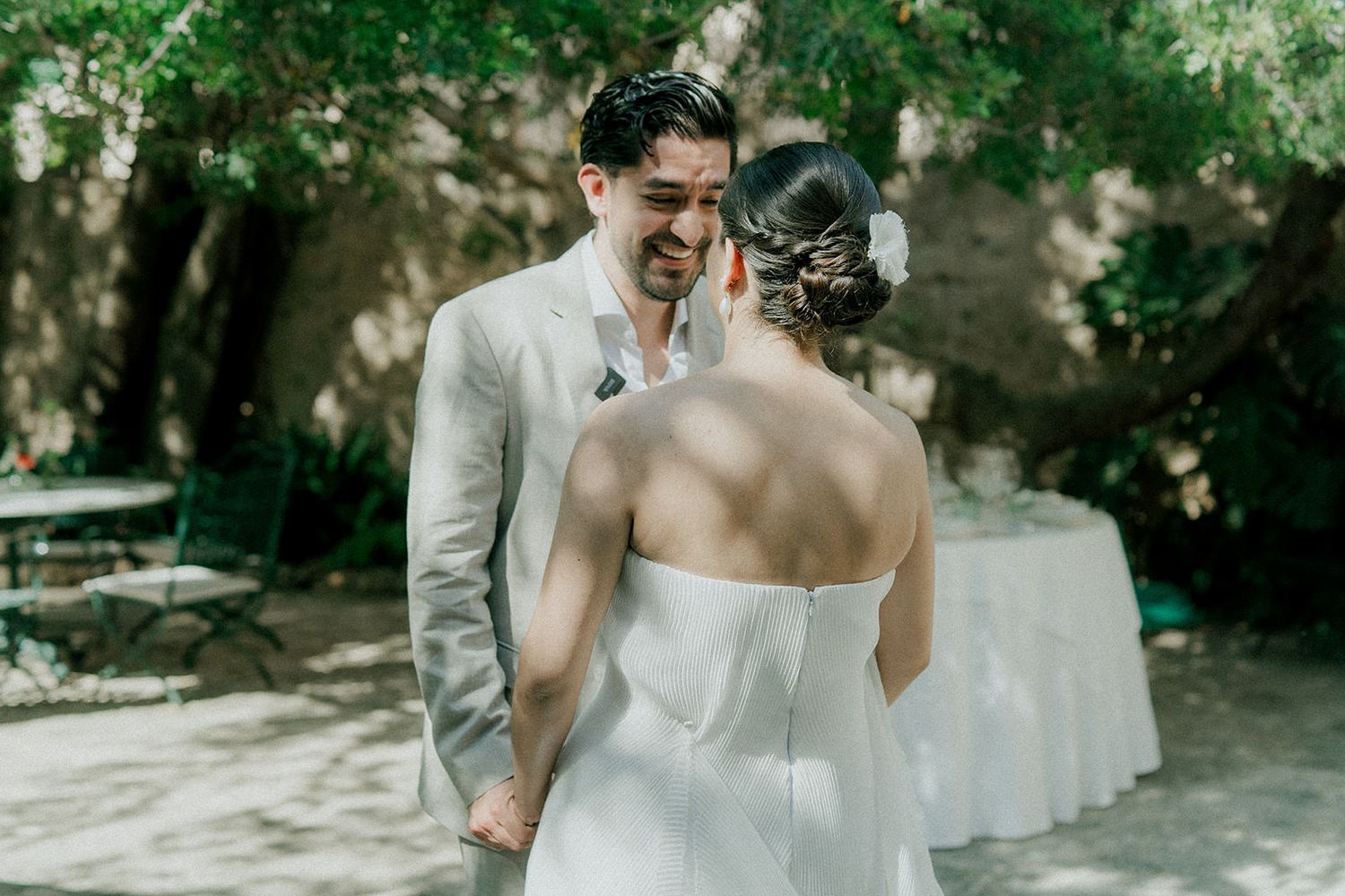 A couple shares a tender moment during their first look at an outdoor garden wedding ceremony.