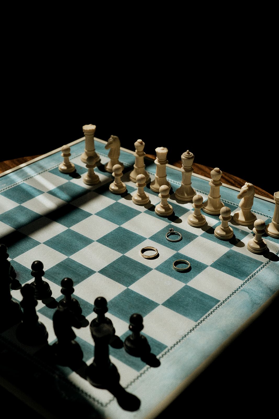 A sequence of chess game positions showing white and black pieces on a green and white checkered board in dramatic lighting.