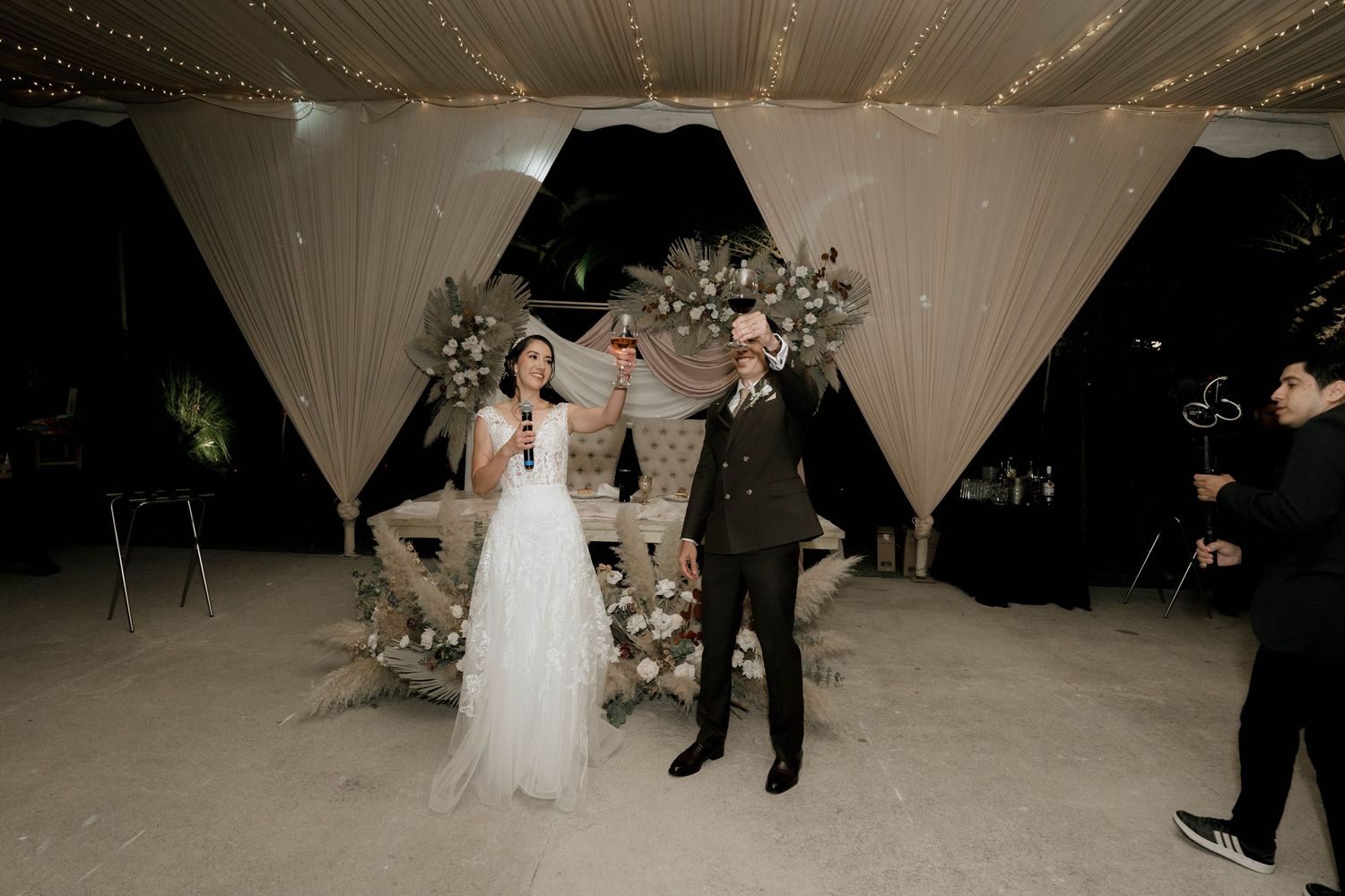 Wedding dance floor with elegant white tent draping and romantic lighting.
