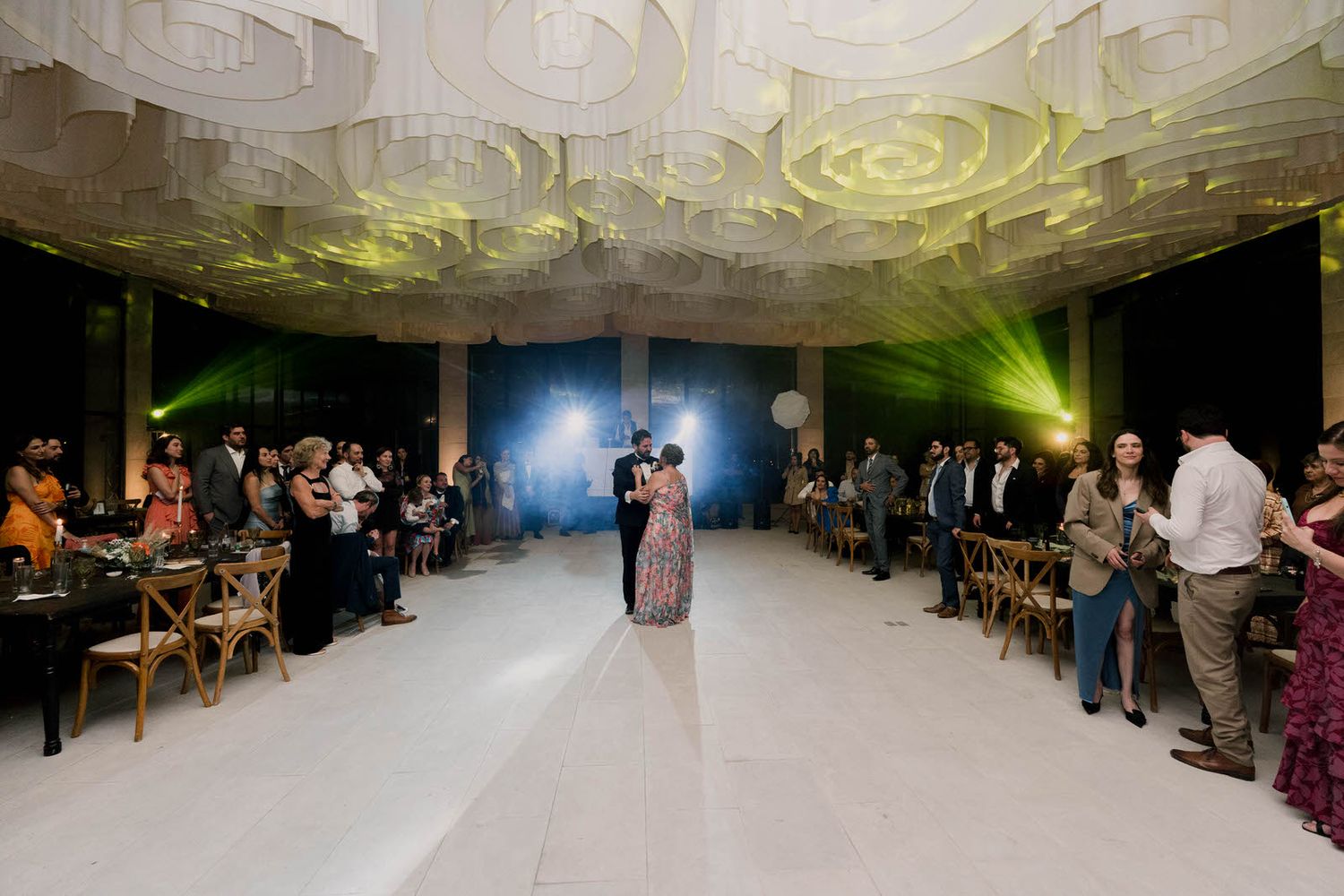 Panoramic view of a wedding reception venue with ornate ceiling patterns and mood lighting.