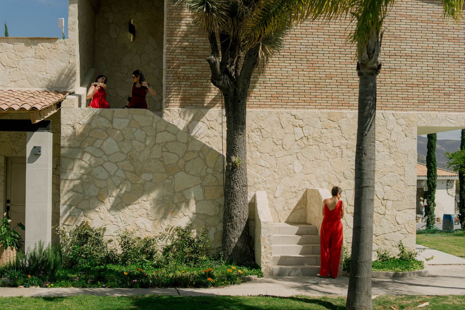 Mediterranean style courtyard with stone walls and tropical plants in sunlight.