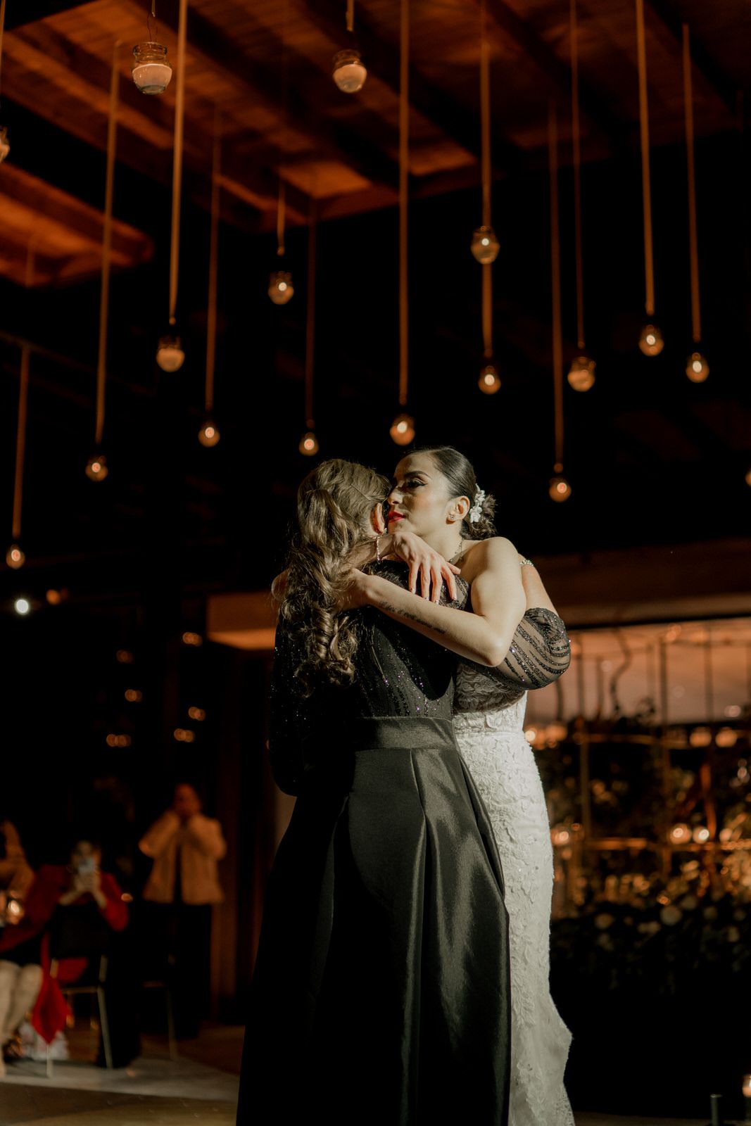 Intimate dance moments captured during wedding reception under warm lighting.