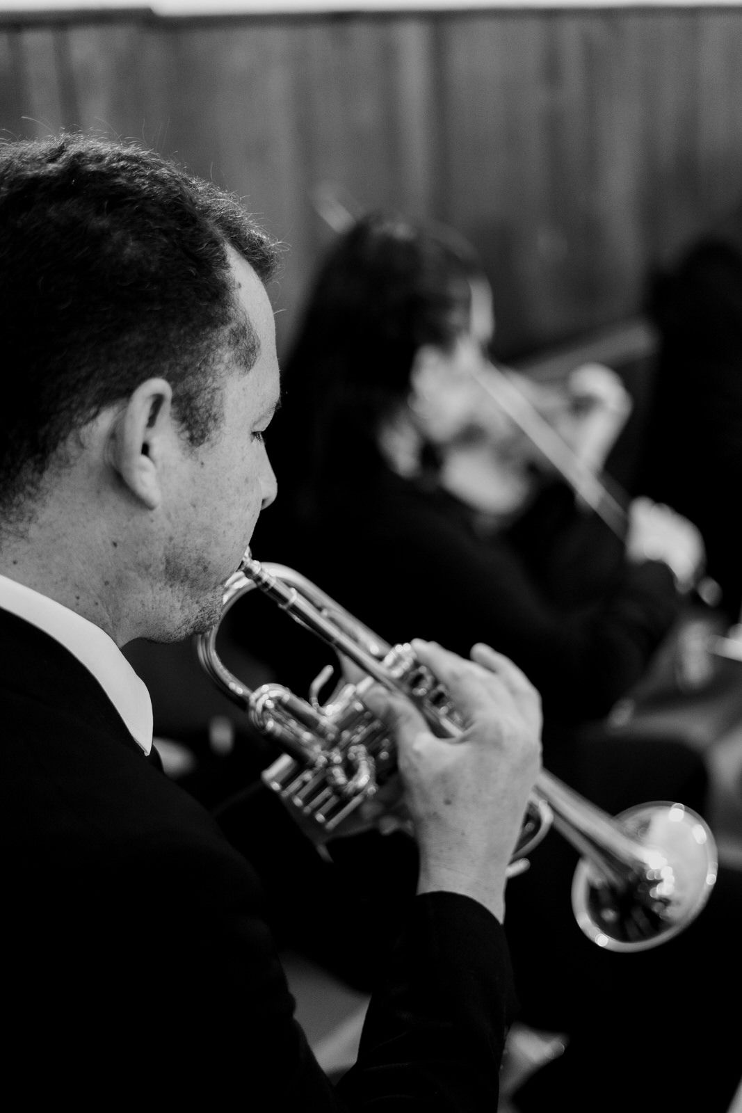A musician plays trumpet during a formal wedding ceremony performance.